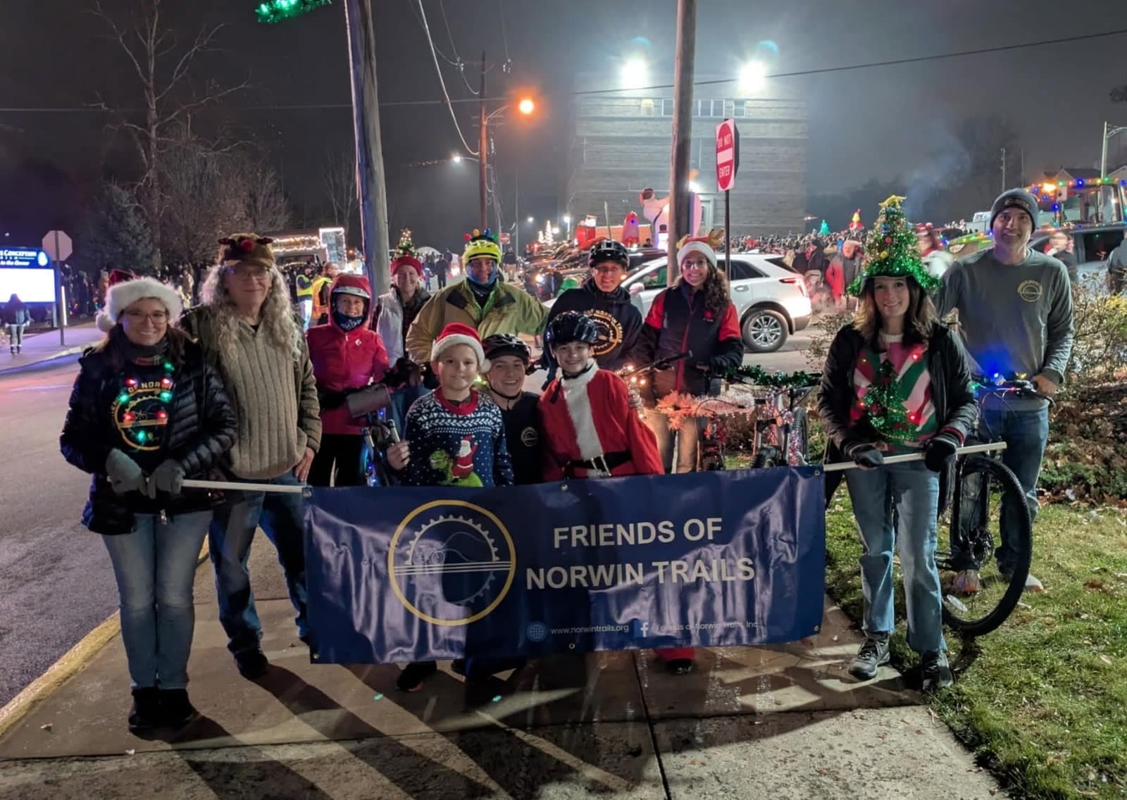 Friends of Norwin Trails members carrying the group banner in a nighttime holiday parade
